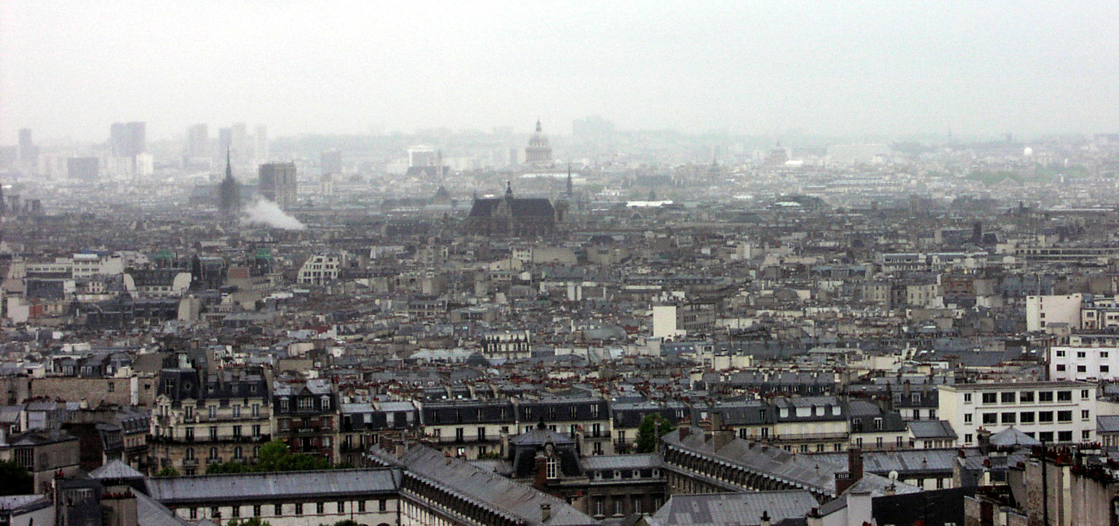 Utsikt från Sacré Coeur över ett regnvått Paris.